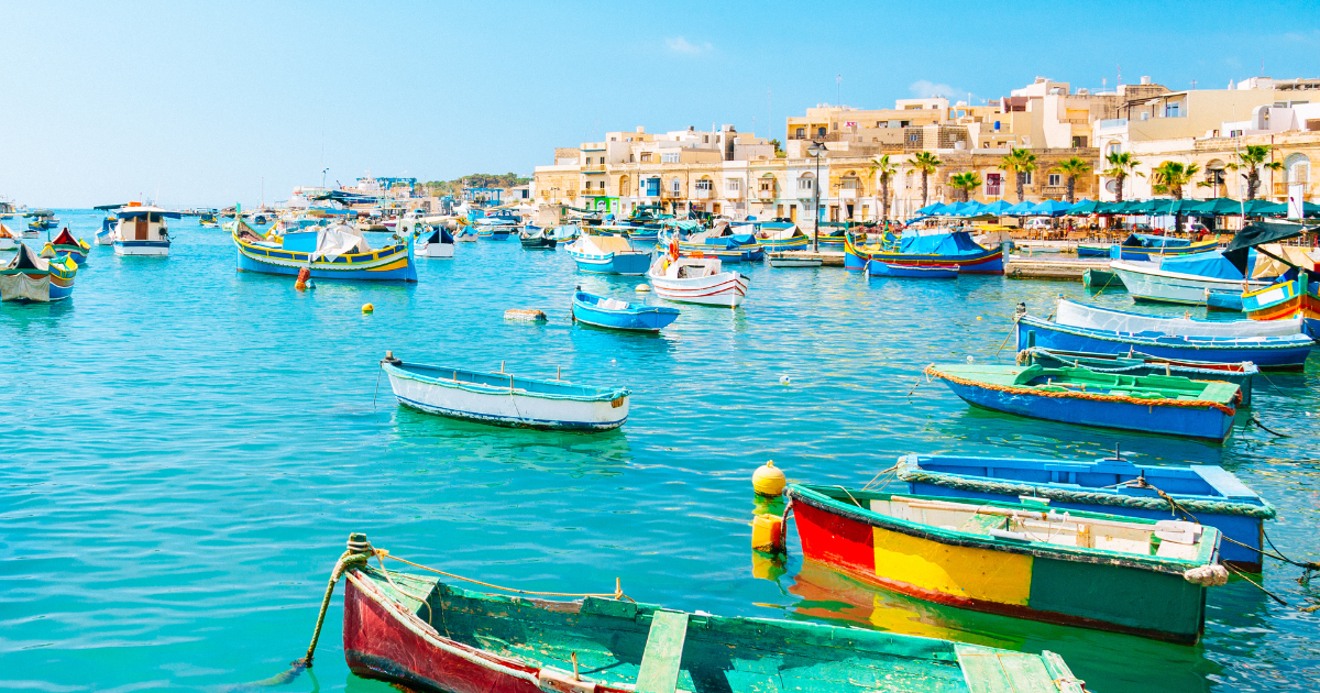 What to see and do in Malta. Colorful boats and limestone buildings.